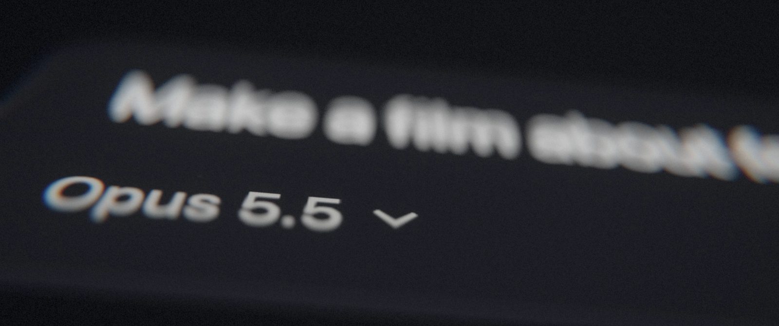 A macro lens over a chat interface: the words 'Make a film about feelings' out of focus above the model name Opus 5.5.
